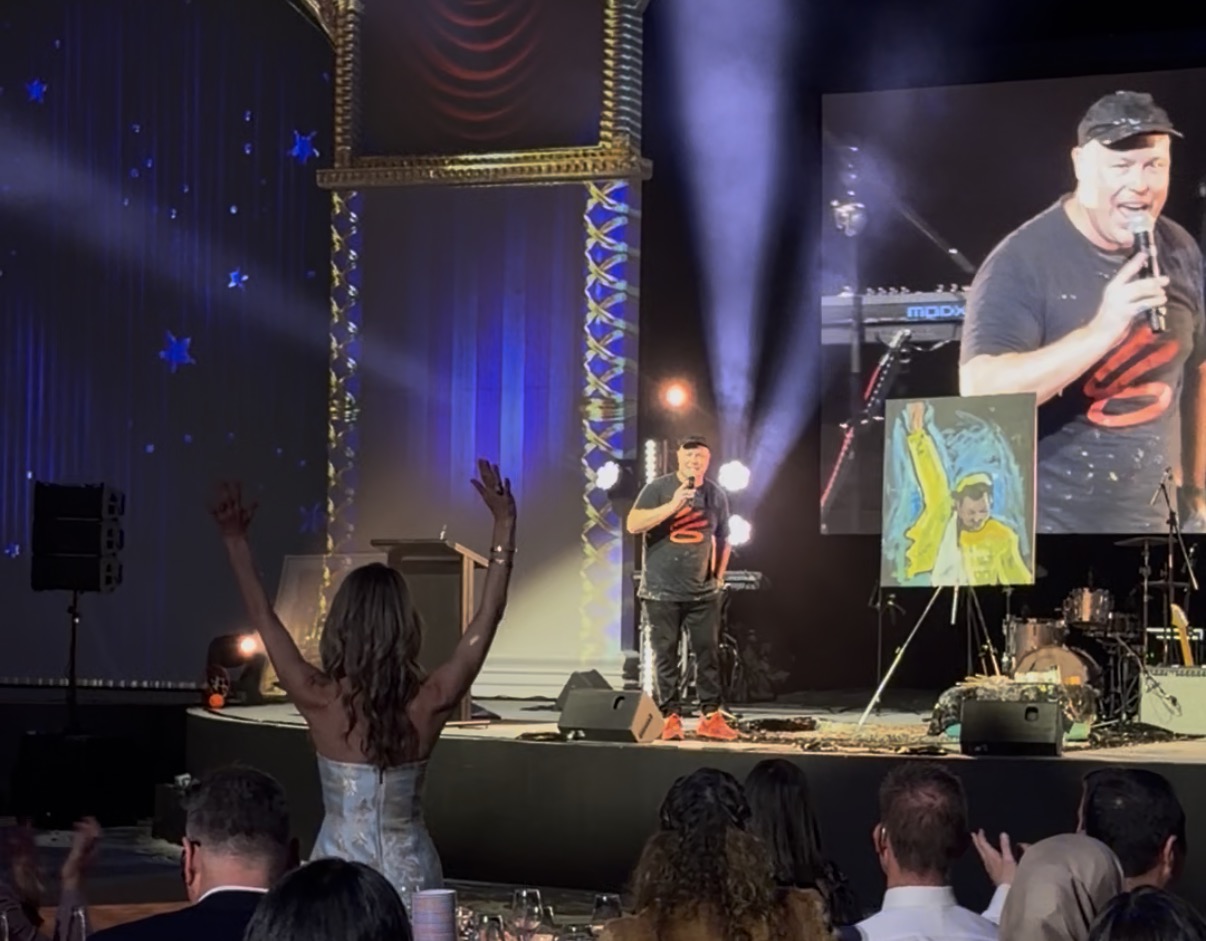 Brad Blaze performing on stage at a gala event